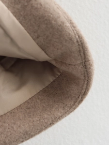 Gros plan détaillé de la veste en tweed kaki montrant les coutures et la doublure