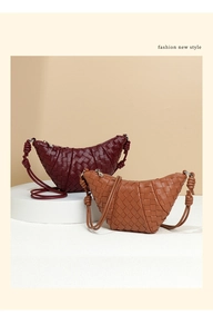 Detail of hand-woven crescent bags in burgundy and tan leather with knotted handle design