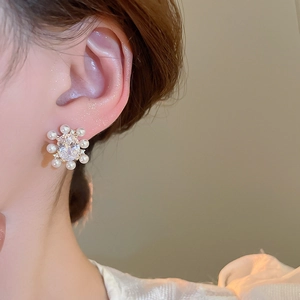 Macro shot of 14k gold plated flower stud earrings featuring pearls and oval zirconia