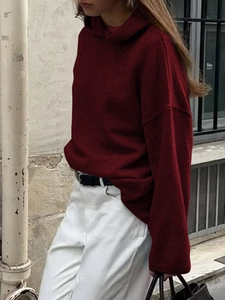 Detail of red long-sleeved hooded knit sweater for women with a relaxed casual fit