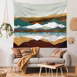 Detailed view of large mountain landscape tapestry hanging above a modern living room sofa