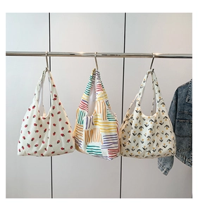 Three corduroy tote bags with strawberry, tulip and geometric prints shown on rack
