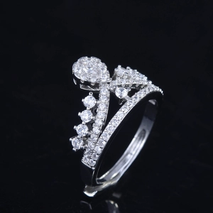 Macro shot of silver crown ring with micro-pave diamonds on black mirror background