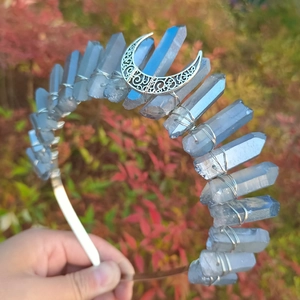Detailed view of handmade light blue crystal crown with crescent moon on a metal band