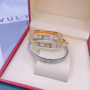 Macro detail of three-piece snake scale bracelets in gold, rose gold and silver finish