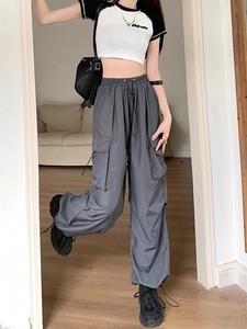 Detail shot of grey cargo trousers showing the high waist drawstring and large side pockets