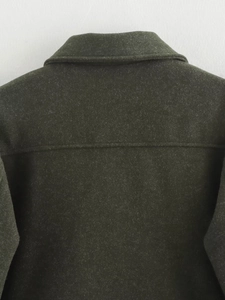 Detail of dark green woolen jacket showing high-quality stitching and fabric texture