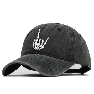 Détail de la broderie main de squelette blanche sur une casquette en coton lavé noir