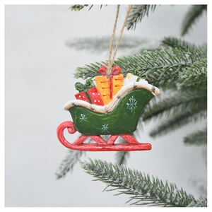 Retro Christmas sleigh ornament with colorful gift boxes hanging on a snowy pine branch