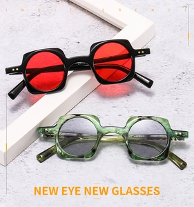 Detail of punk square frame sunglasses with round lenses in red and smoke tints
