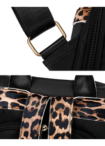 Detail of leopard print straps and gold hardware on a lightweight black oxford backpack