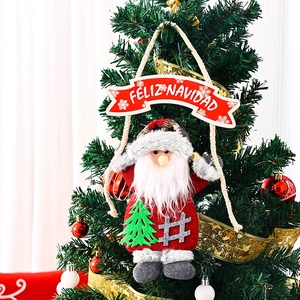 Detail of Santa plush ornament with Feliz Navidad banner on decorated Christmas tree