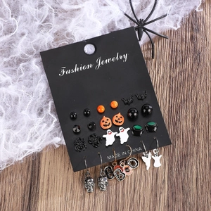 Flat lay of Gothic Halloween earring set featuring pumpkins and spiders on wood texture