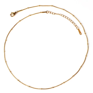 Close-up of golden stainless steel snake chain necklace with beads and lobster clasp