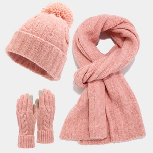 Close-up of pink knit winter set with faux fur pom-pom hat and touchscreen gloves
