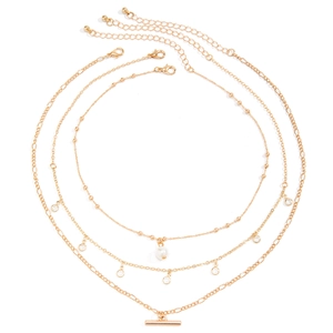 Detail of gold layered necklace set featuring faux pearl, zircon accents and t-bar pendant
