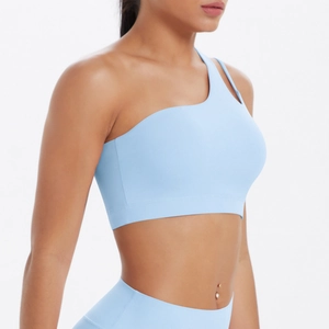 Detail of light blue one-shoulder sports bra with cut-out strap and high-waist yoga pants