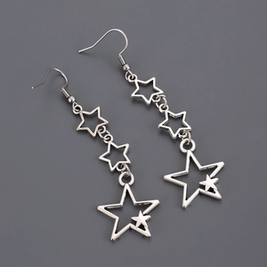 Détail de boucles d'oreilles étoiles argentées avec triple pendentifs ajourés