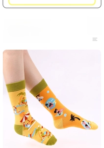 Detail of yellow cotton socks with summer beach palm tree prints and green ribbed cuffs