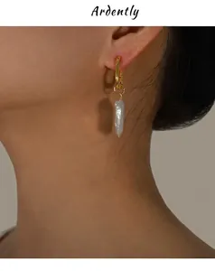 Close-up of model wearing gold baroque freshwater pearl earrings with soft lighting