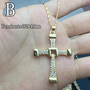 Gold cross pendant necklace with zircon inlay held in hand, measuring 32 by 44 mm