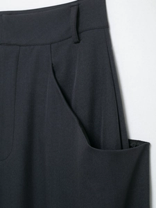 Detailed close-up of dark grey high-waisted wide-leg trousers featuring belt loops and side pockets