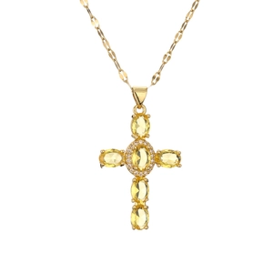 Close-up of gold necklace with a cross pendant set with yellow oval zircons and crystals