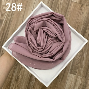 Détail d'un châle en mousseline rose poudré avec fine texture pailletée et légère