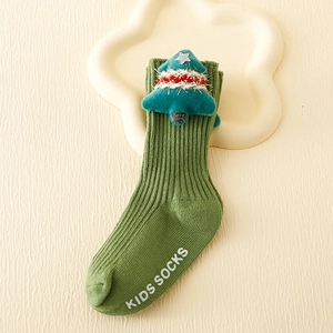 Detailed knit texture of green kids Christmas sock with a plush 3D tree accessory