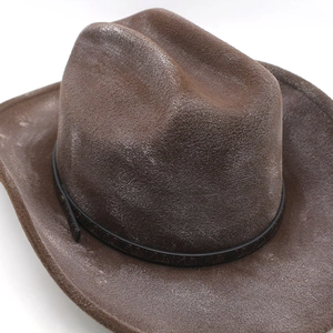 Detail of brown distressed cowboy hat featuring a wide brim and dark leather belt with buckle