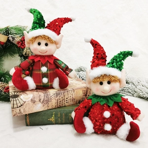 Sitting Christmas elf dolls in red and green sequins on vintage books decoration