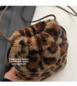 Detail view of the drawstring design and soft leopard faux fur on the mini bucket handbag
