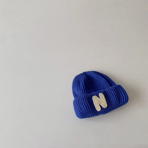 Detailed view of dark blue knit beanie featuring high-quality white N letter patch