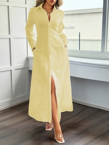 Dettaglio di un abito a camicia giallo a maniche lunghe con bottoni e spacco laterale