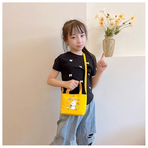 Girl wearing a cute yellow canvas messenger bag with cartoon rabbit print for kids