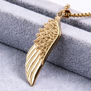 Macro view of golden stainless steel feather pendant with detailed engraved textures