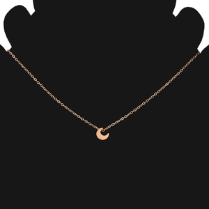 Close-up of minimalist rose gold crescent moon pendant on a delicate chain necklace