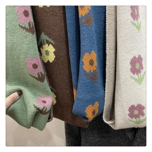 Detailed knit texture of vintage floral scarves in green, brown, blue, and beige colors