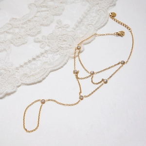 Close-up of gold stainless steel slave bracelet with zircon stones and lace detail