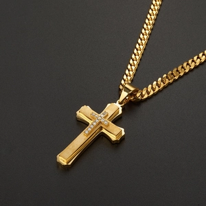 Close-up of golden multi-layer cross pendant with zircon stones on a Cuban chain