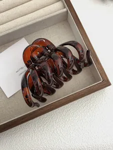 Macro detail of large tortoise shell amber hair claw clip with polished finish