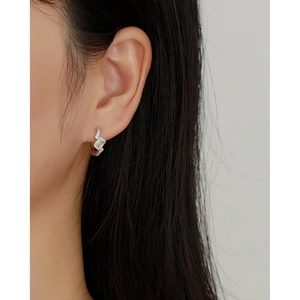 Close-up of S925 silver hoop earrings with clear rectangular gemstone on model