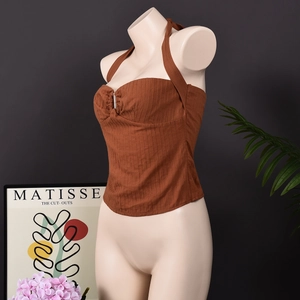 Dettaglio del crop top marrone con allacciatura al collo, tessuto a coste e fibbia