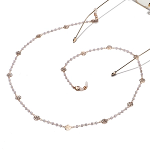 Elegante Brillenkette mit weißen Perlen und goldenen Rosenanhängern auf weißem Grund