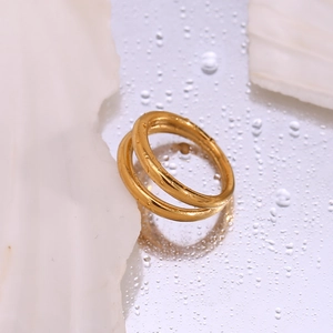 Detailed macro of 18K gold plated double layer ring on mirror with water droplets