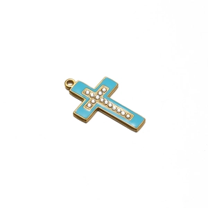 Detail of gold cross pendant with light blue enamel and sparkling crystal inlay