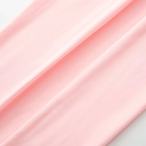 Gros plan sur le tissu en maille côtelée rose montrant la texture et les coutures du body