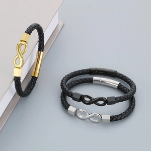Detail of woven leather bracelets with infinity symbols in gold, silver and black metal