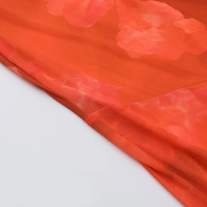 Détail de l'imprimé floral orange sur tissu en maille semi-transparent avec coutures nettes
