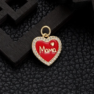 Macro shot of gold-plated Mama heart pendant with red enamel and sparkling crystal stones